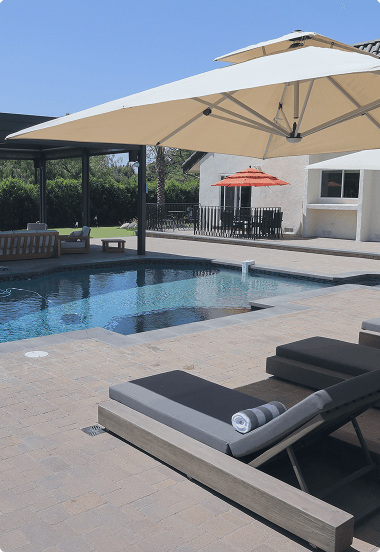 Pool area featuring a shaded lounge chair, perfect for relaxing in comfort
